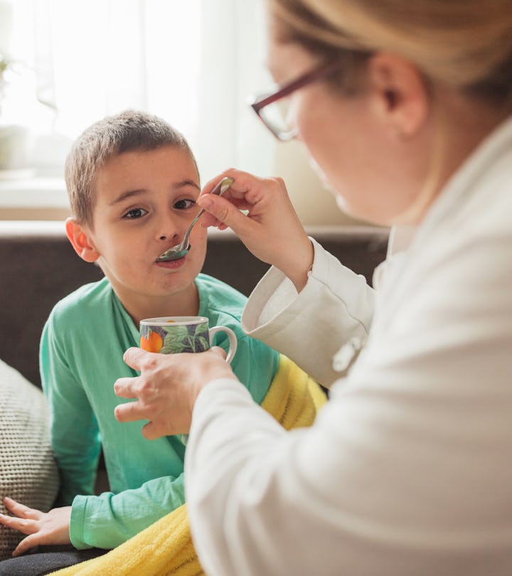 A mom feeds her child soup with a spoon, in a story explaining how sick is too sick to go to school.