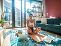 A young woman works out at home with the 3-2-8 pilates workout from TikTOk.