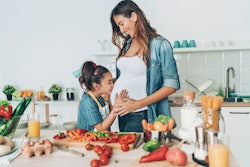 Pregnant young woman and her daughter together in the kitchen can you have spicy food while pregnant...