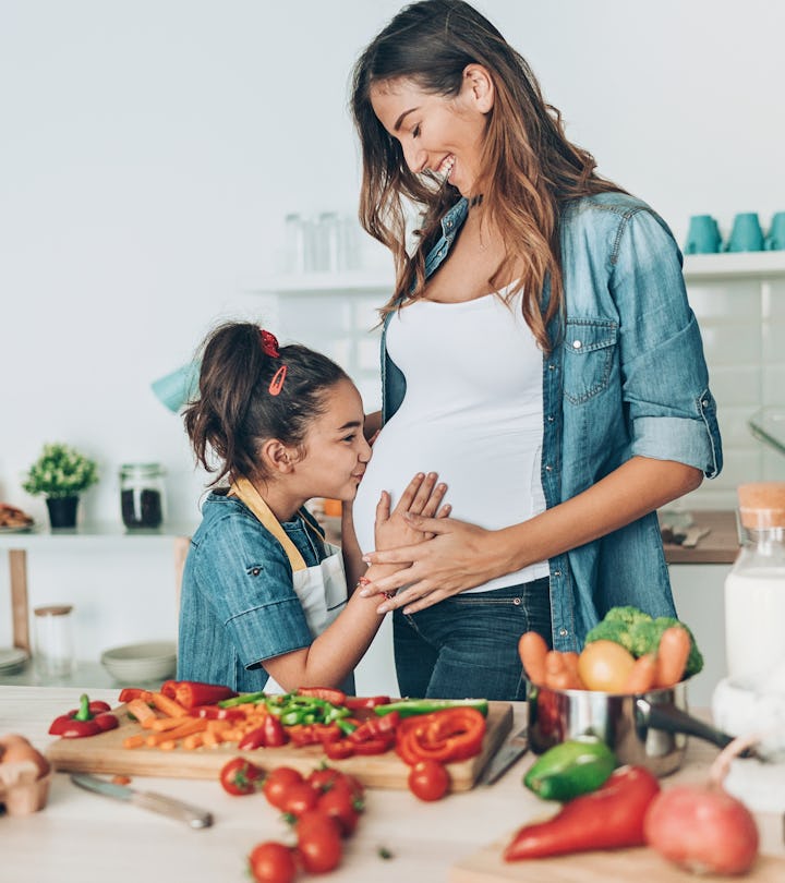 Pregnant young woman and her daughter together in the kitchen can you have spicy food while pregnant...