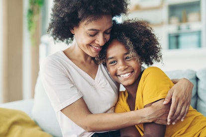 Smiling mother embracing her daughter in an article about how to deal with a child who cries over ev...