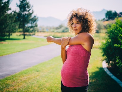 A pregnant woman jogging in a park in an article about cramps after walking during pregnancy