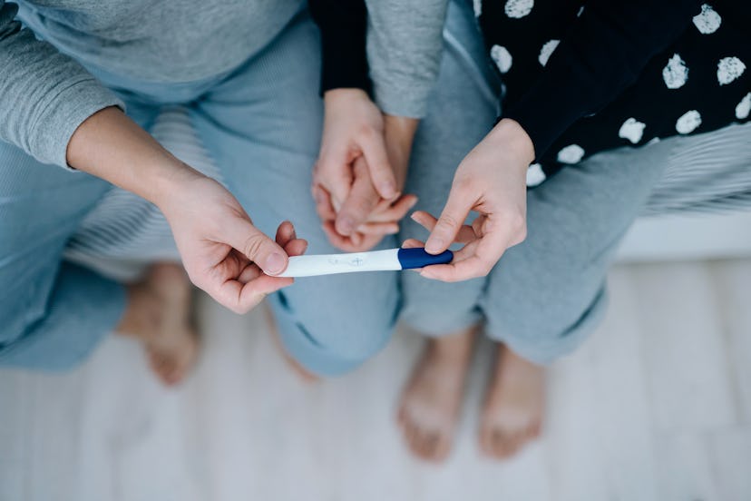 couple holding a positive pregnancy test together.what happens if you leave a pregnancy test out too...