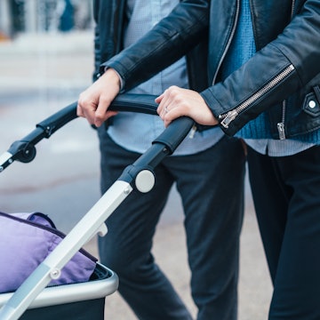 A couple walking with a stroller. The Ella AI Powered Smart Stroller debuted at CES 2023, and the se...