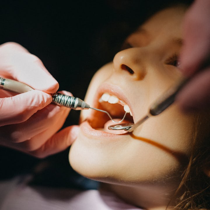 Child having their teeth checked by a dentist. Dentists have seen an uptick in cavities since quaran...
