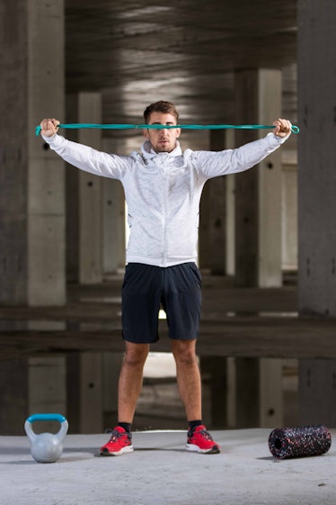 Fit healthy caucasian athlete training with rubber band outside