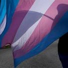 A marcher carries a Transgender Pride flag during a march in Kansas City. Lawmakers in Kansas and Mi...