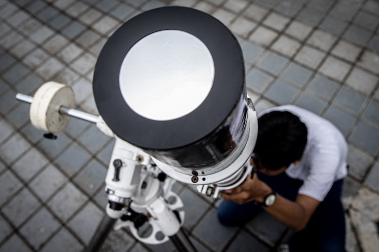 SURABAYA, INDONESIA - APRIL 20: Indonesian observes hybrid solar eclipse using a solar telescope on ...
