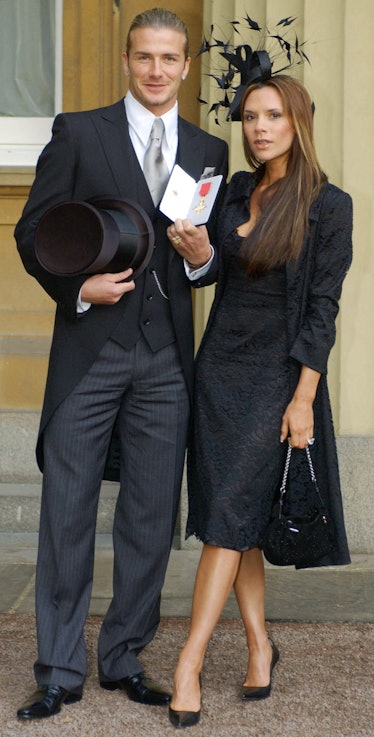England's football captain David Beckham stands with his wife, Victoria, as he shows off the OBE 