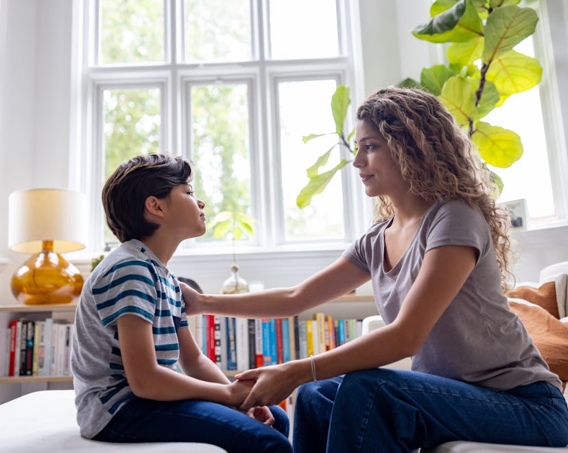 Loving mother comforting her son while talking at home - lifestyle concepts
