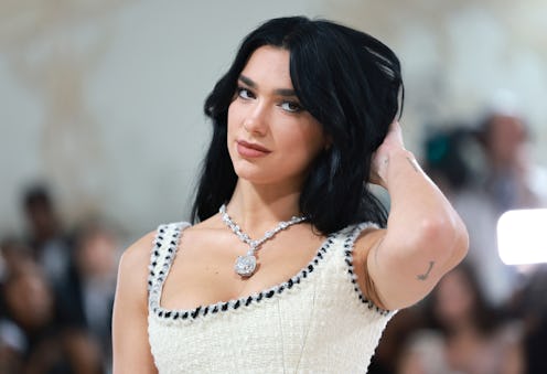 Dua Lipa debuted cherry coke red hair on Instagram. Here, the singer with black hair at the 2023 Met...