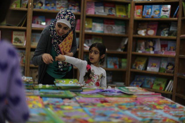 A mother and daughter peruse books at a local book fair. 