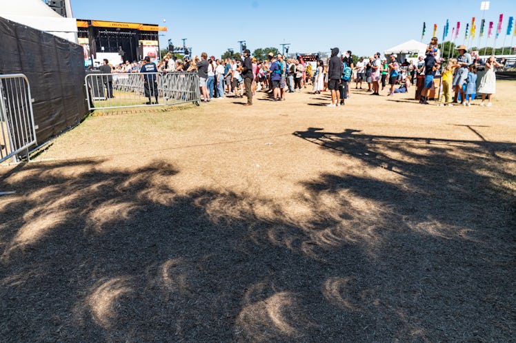 AUSTIN, TEXAS - OCTOBER 14: Crescent shadows appear on the ground during the solar eclipse at 2023 A...