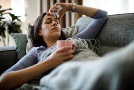 Sick woman lying in bed, in a story answering the question, why is hand, foot, and mouth worse for a...
