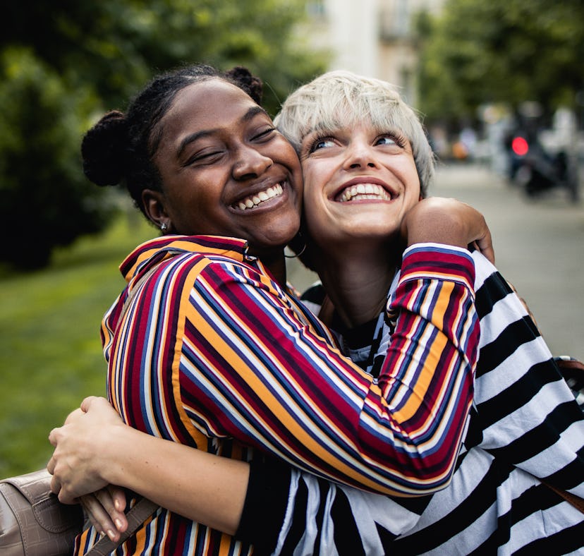 two friends embrace for a photo as they consider why the October 2023 lunar eclipse will affect four...
