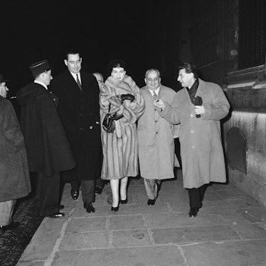 Opera singer Maria Callas (1923-1977) walks down a Paris sidewalk with her husband, Italian industri...