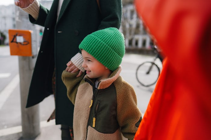 Photo of a young boy and his family exploring streets of a new city and wandering around; he appreci...