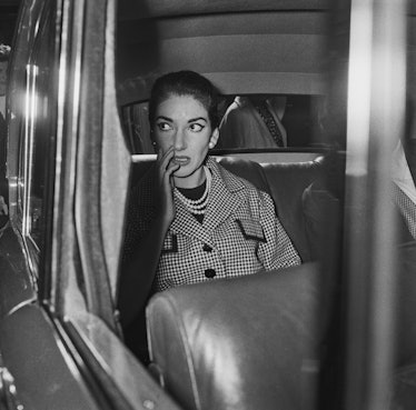 American-born Greek soprano Maria Callas (1923 - 1977) sitting in the back of a car outside the Savo...