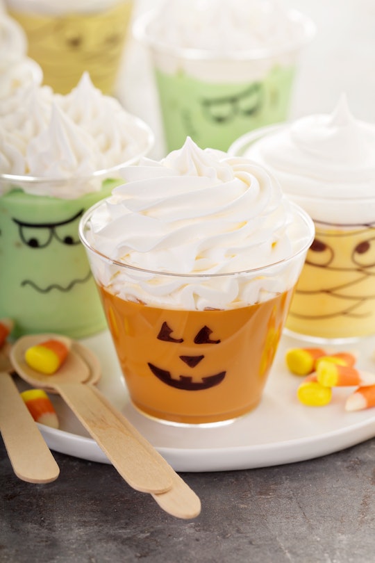 Funny Halloween themed puddings in cups with whipped cream
