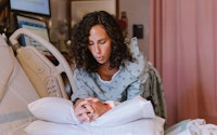 A pregnant woman leans against pillows and breathes through contractions, reciting birth affirmation...