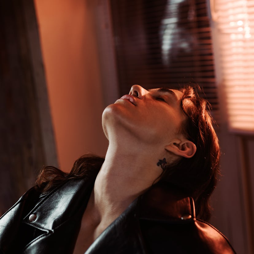 a young person tilts their head back and poses in a leather jacket as they consider their October 20...