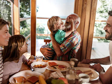 Happy extended family enjoying their meal at dining table.