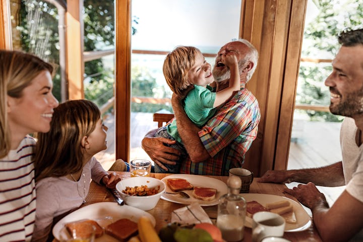Happy extended family enjoying their meal at dining table.