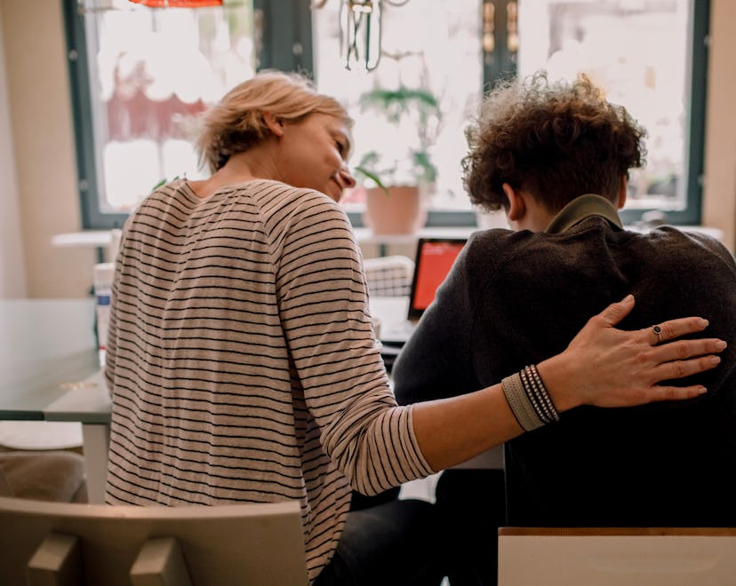 mom helping and talking with teenage son at table in article about affirmations for parents of teena...