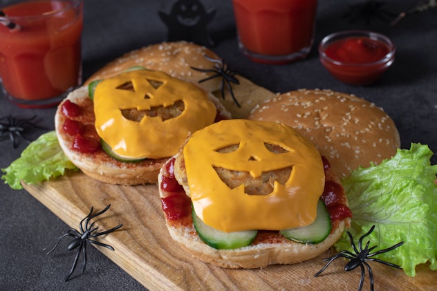Two funny monster chicken burgers with toast cheese, ketchup and cucumber. Creative Halloween lunch ...