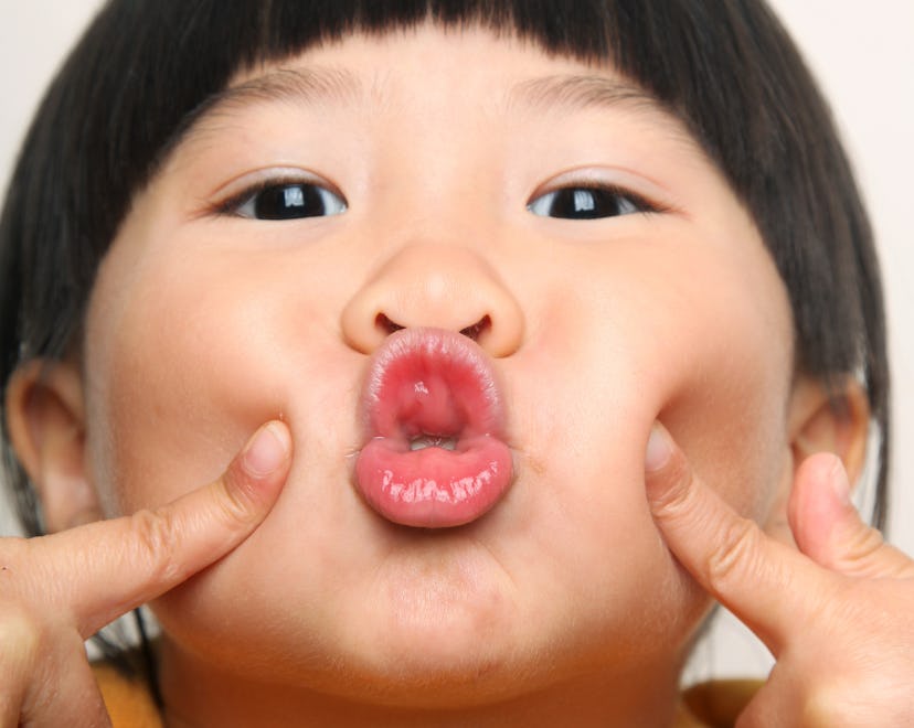 Portrait of little Asian girl blowing kiss to camera