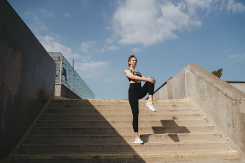 Beautiful woman stretching during her workout in the city