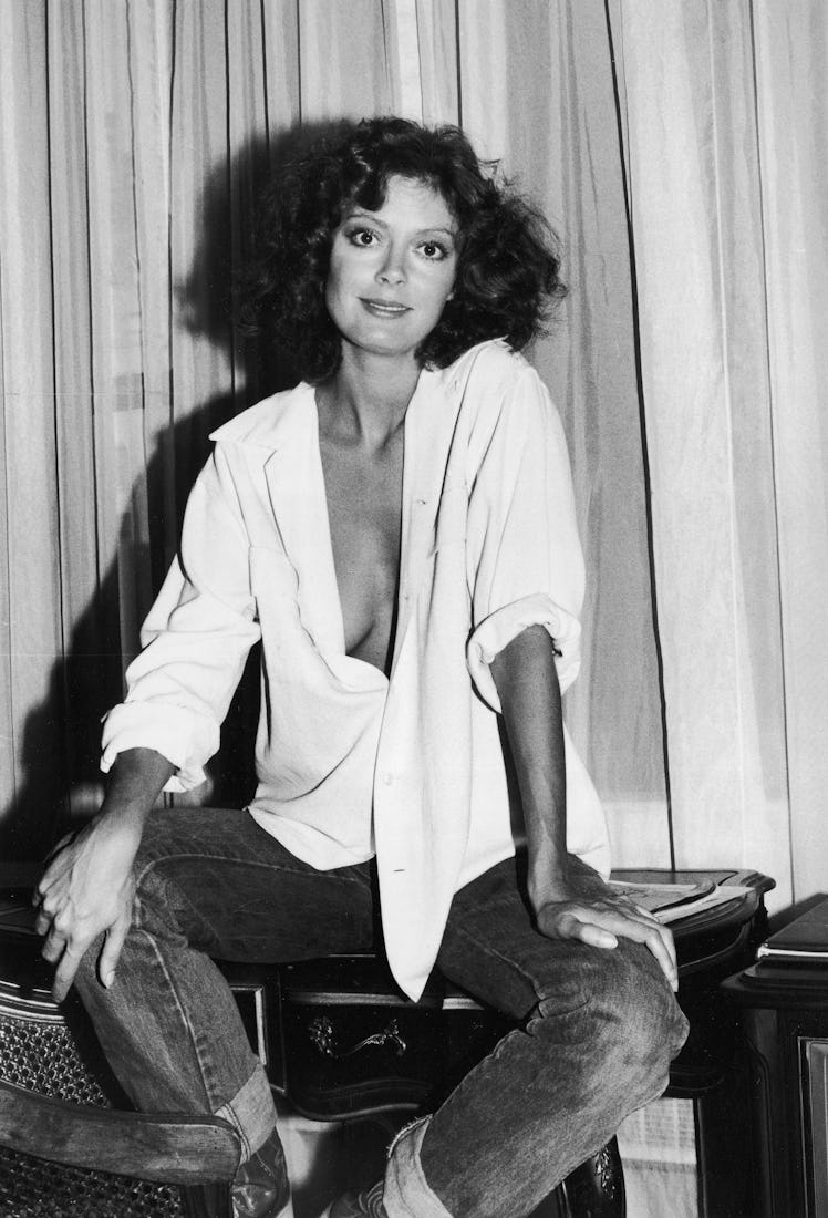 Susan Sarandon sitting on a desk with her shirt unbuttoned to reveal her cleavage, Warwick Hotel, Ne...
