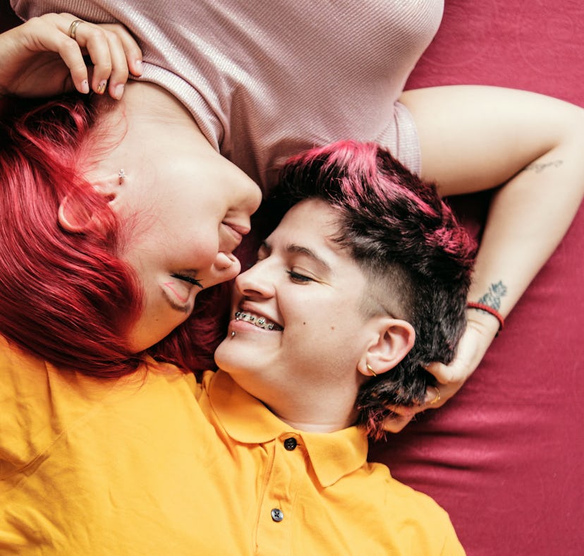 a young couple cuddles as they lay down, and consider why the 2023 Libra solar eclipse will affect t...