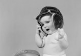 UNITED STATES - CIRCA 1940s:  Baby girl wearing leather football helmet.