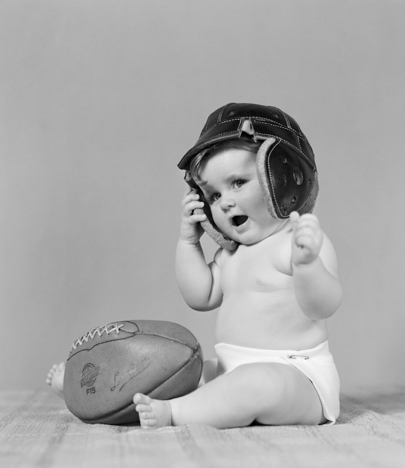 UNITED STATES - CIRCA 1940s: Baby girl wearing leather football helmet.