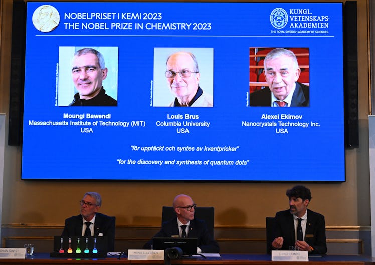 A screen shows this year's laureates US Chemist Moungi Bawendi, US Chemist Louis Brus and Russian ph...
