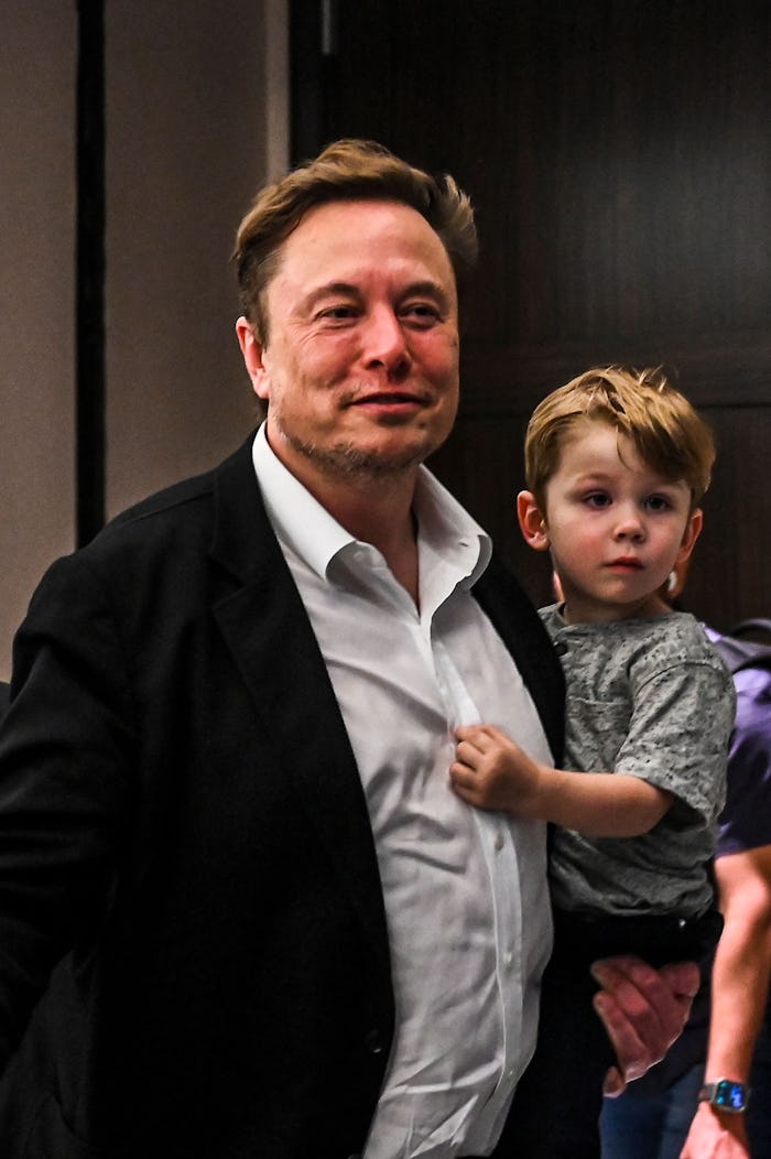 Twitter CEO Elon Musk holds one of his children after a keynote speech at the "Twitter 2.0: From Con...