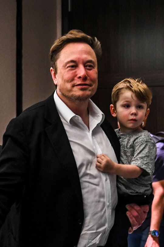Twitter CEO Elon Musk holds one of his children after a keynote speech at the "Twitter 2.0: From Con...