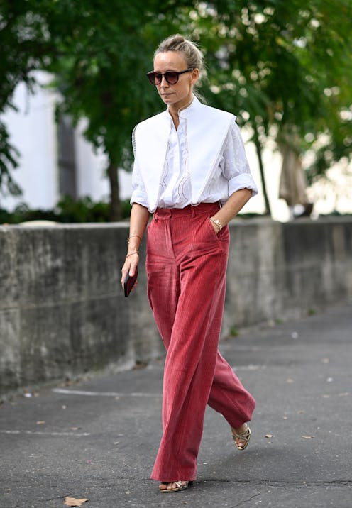 PARIS, FRANCE - OCTOBER 02: A guest is seen wearing a white layered shirt, red pants and red sunglas...