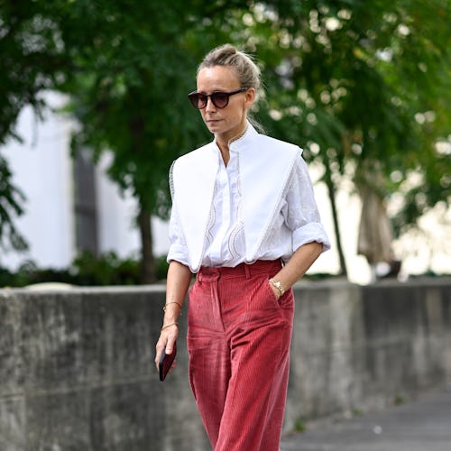 PARIS, FRANCE - OCTOBER 02: A guest is seen wearing a white layered shirt, red pants and red sunglas...