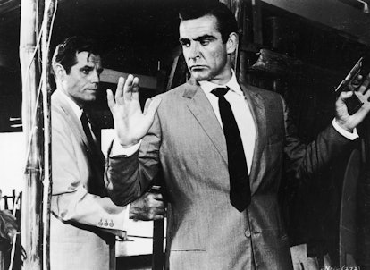 Jack Lord hold Sean Connery at gunpoint in a still from the James Bond film, 'Dr. No,' directed by T...