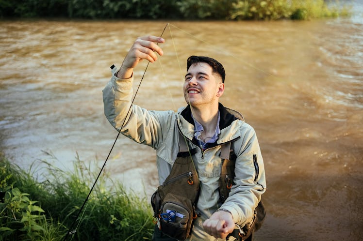 Male fisherman prepares a fishing rod