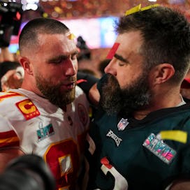 GLENDALE, AZ - FEBRUARY 12: Travis Kelce #87 of the Kansas City Chiefs speaks with Jason Kelce #62 o...