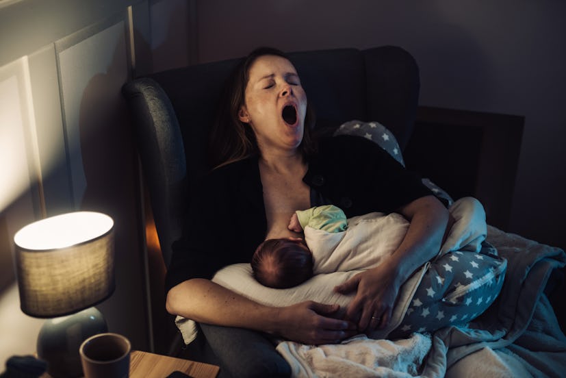 Tired mother yawning while doing breastfeeding at home at night, in a story about affirmations for n...