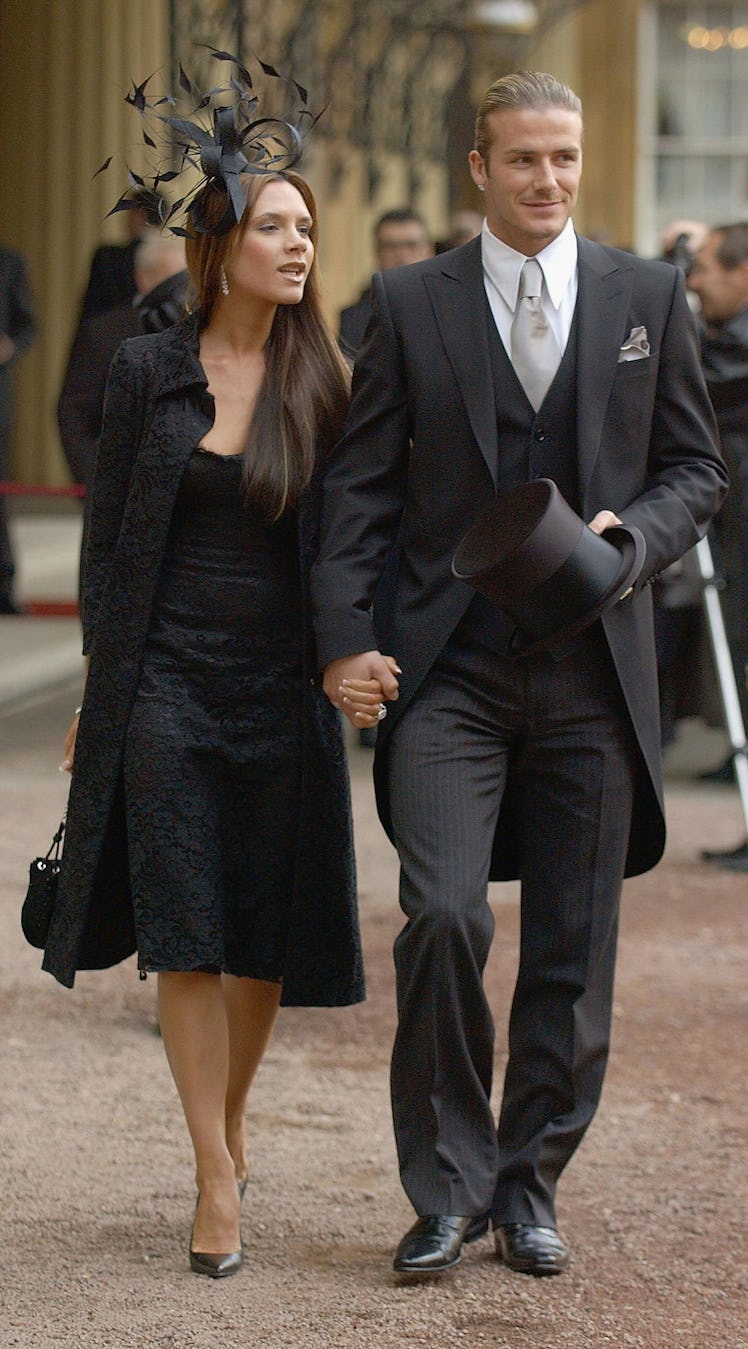 England football captain David Beckham walks with his wife Victoria, as he shows off the OBE (Office...