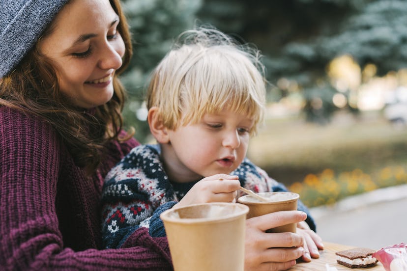 Young Caucasian woman  drinking coffee with little boy
