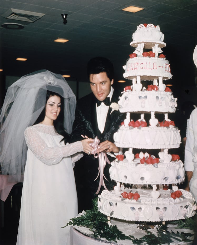 (Original Caption) Las Vegas, Nevada, Entertainer, Elvis Presley cuts wedding cake with his bride, t...