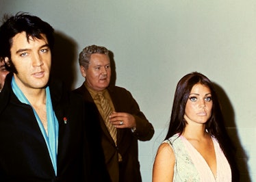 American singer Elvis Presley (1935 - 1977) walks with his wife, actress Priscilla Presley and fathe...