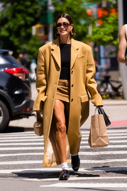 Hailey Bieber wears a camel coat and mini skirt in New York. 