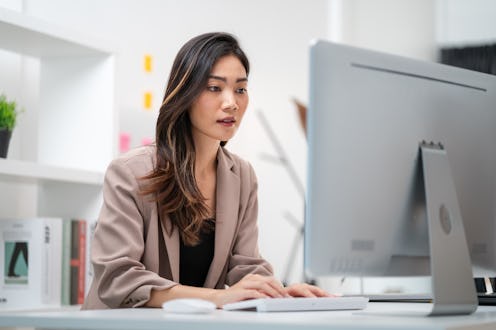 Business woman sitting in front of computer screen to plan business work
